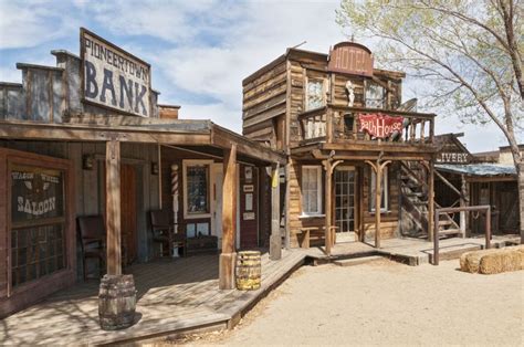 an old western town with wooden buildings and signs on the building's ...