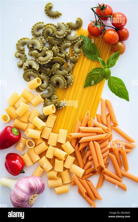 Different types of pasta with ingredients on white background, flat lay ...