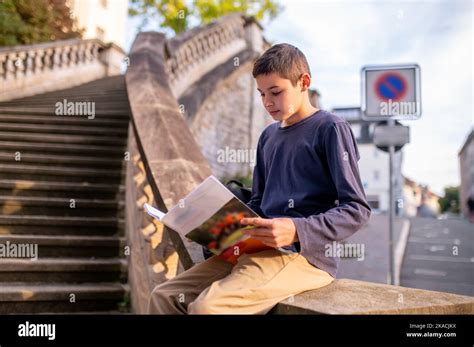 Boy involved in reading a book outdoors Stock Photo - Alamy