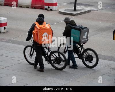 Just Eat courier delivery rider in orange uniform and Just Eat Scooter ...