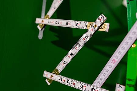 Royalty-Free photo: Extandable wooden ruler on a green background | PickPik