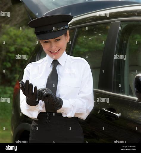 Woman chauffeur wearing a hat and putting on her uniform black leather gloves Stock Photo - Alamy