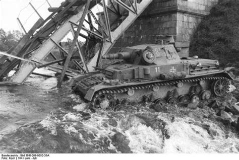 an old tank is in the water near a bridge that has been knocked over by flood waters