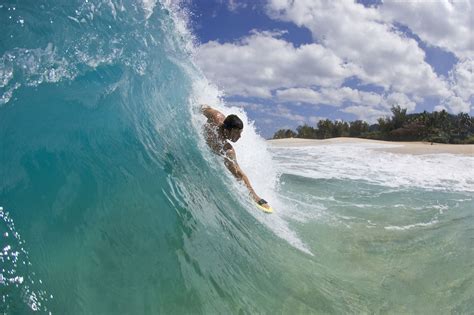 A young man body surfing at Keiki Beach on the North Shore of Oahu ...