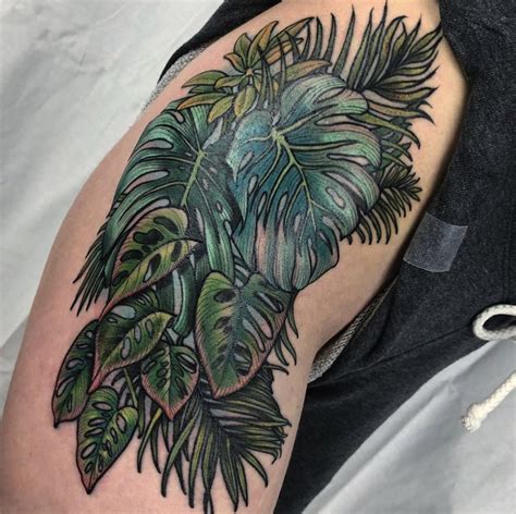 Tropical inspired thigh piece tattoo featuring leaves and foliage from the monstera plant, and ...