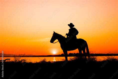 cowboy on horse with sunset landscape Stock Photo | Adobe Stock