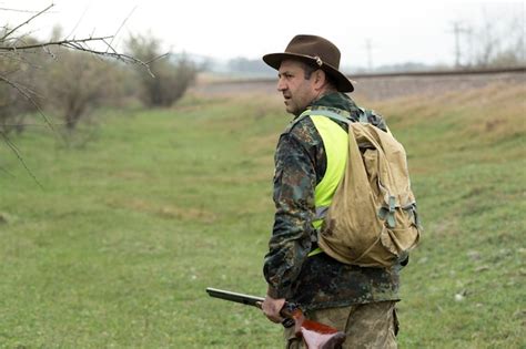 Premium Photo | Pheasant hunters with shotgun walking through a meadow