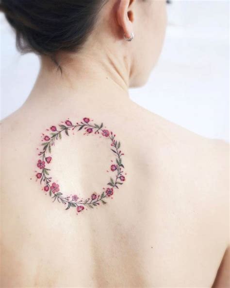 Cherry blossom flower wreath tattoo on the upper back.