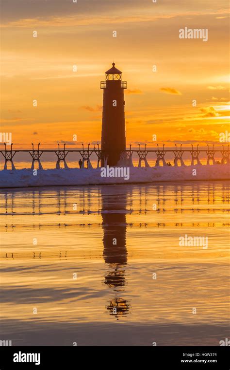 Grand Haven Lighthouse at sunset, at the mouth of the Grand River where ...