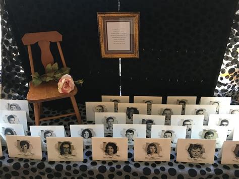 a table topped with lots of cards next to a wooden chair and framed ...