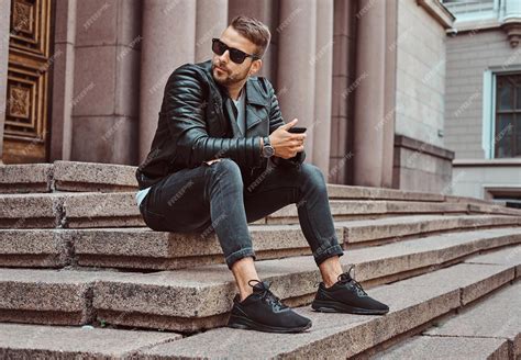 Free Photo | Fashionable guy dressed in a black jacket and jeans holds ...