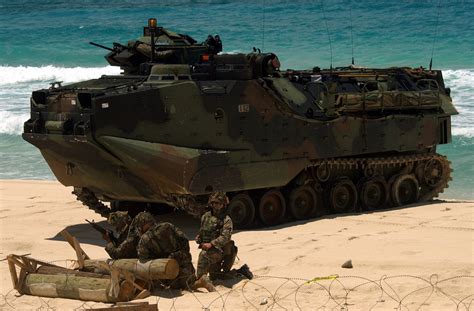 US Marine Corps (USMC) Marines, 3rd Battalion, 3rd Marine Regiment, guard their AAV7A1 Assault ...