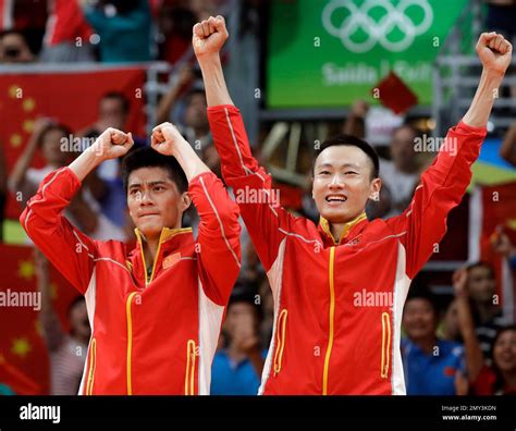 China's Fu Haifeng, left, and Zhang Nan celebrate on the winners' stand ...