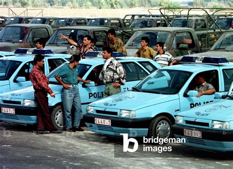 Image of Palestinian police in civilian clothes gather around their ...