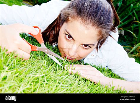 Woman cutting grass with scissors Stock Photo - Alamy