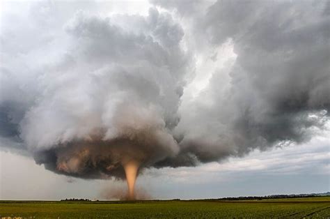 A 'cone' shaped tornado below its thick cumulonimbus supercell, churns up fertile Iowan soil In ...