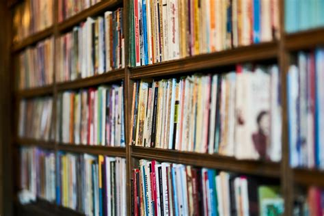 Assorted Books on Wooden Shelf · Free Stock Photo