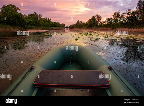 Fishing boat on lake under sunset sky Stock Photo - Alamy