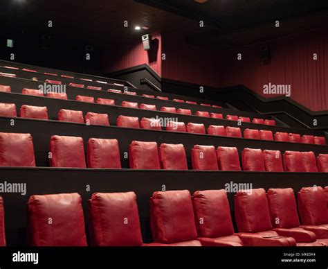 Rows of luxury red movie theater seats in an empty movie theater Stock Photo - Alamy