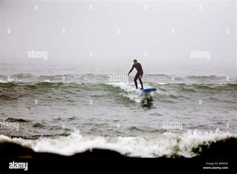 Surfing waves of Far Rockaway Beach during very foggy day New York USA Stock Photo - Alamy