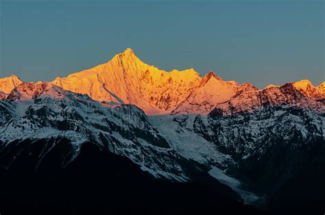 The golden light on the mountain peak at sunrise Photograph by Weiwei ...