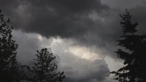 Timelapse video of increasingly dark grey rain clouds moving across a ...