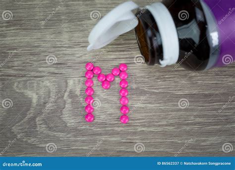 Pink Pills Forming Shape To M Alphabet On Wood Background Stock Image ...