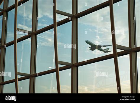 Airplane taking off on international flight as seen through lobby ...