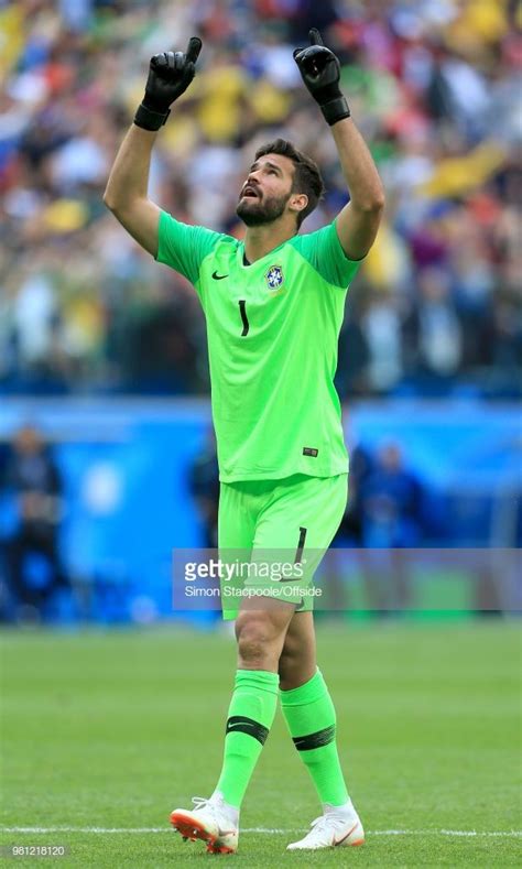 Brazil goalkeeper Alisson Becker points skywards as he celebrates... | Guantes de fútbol ...