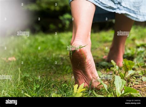 Woman walking barefoot on grass Stock Photo - Alamy