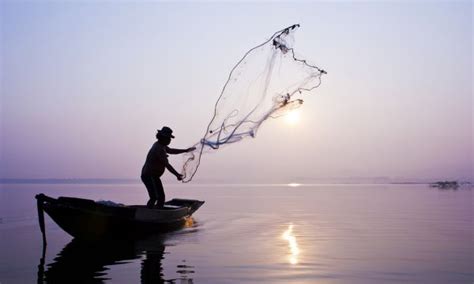 Fishermen are catching fish with a cast net. - Stock Image - Everypixel