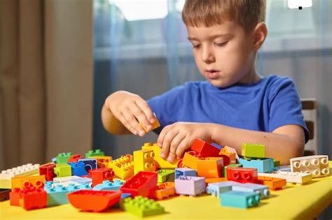 Premium Photo | Boy playing with plastic toy at home