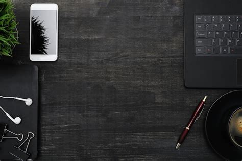 Free Photo | Workplace with smartphone, laptop, on black table. Top view copyspace background