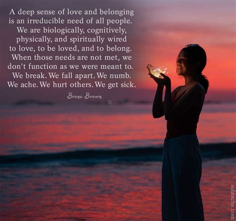 a woman standing on the beach holding a lit candle in her hand with a sunset behind her