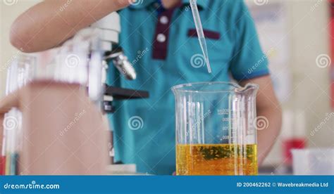 Boy Wearing Face Mask and Protective Glasses Using Pipette and Beakers in Laboratory Stock ...