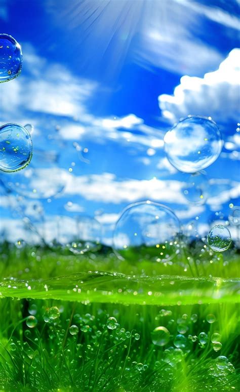 soap bubbles floating in the air over green grass and blue sky with white fluffy clouds