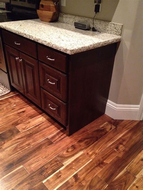 Acacia floor with dark cabinetry and light granite countertops. #kitchen #granite #acacia Light ...