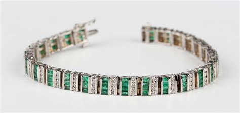 A white gold, emerald and diamond bracelet, designed as rows of four circular cut diamonds alternati