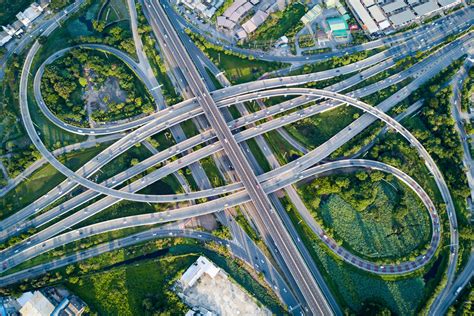 Aerial view of road interchange or highway intersection with busy urban traffic speeding on the ...