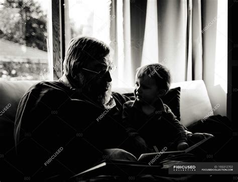 Silueta del abuelo leyendo a su nieto en casa — en blanco y negro ...