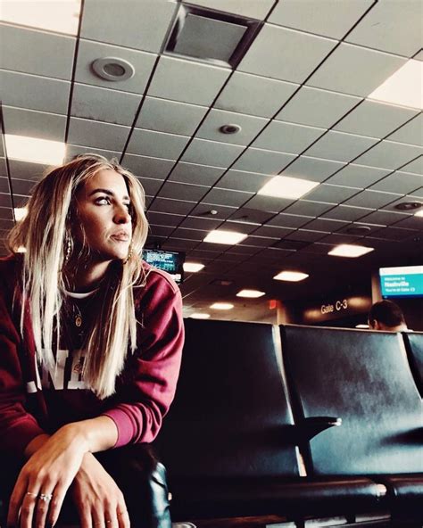 a woman sitting in an airport waiting for her flight