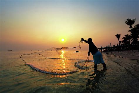 Fisherman Catching A Fish by Monthon Wa