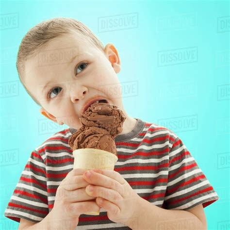 Caucasian boy eating ice cream cone - Stock Photo - Dissolve