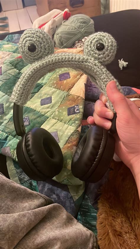 a person is holding headphones in front of a teddy bear and stuffed animal on a bed