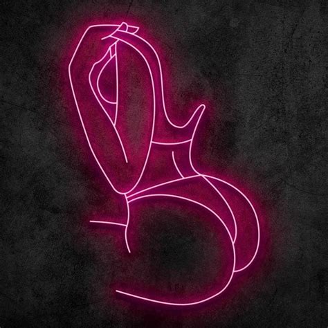 a pink neon sign that is on the side of a black wall and has a woman's ...