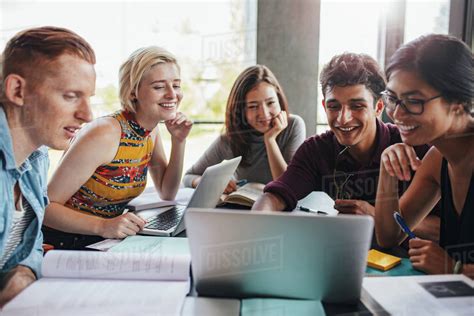 Multiracial group of young students studying in the library. Young ...