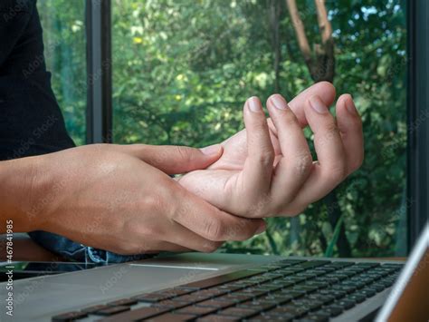 Hand pain from using a computer. Close-up man holding his wrist near ...