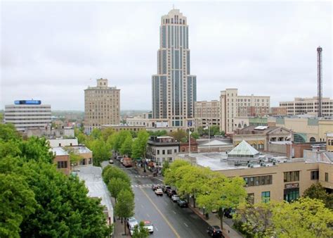 a city with tall buildings and lots of trees in the foreground, on a ...