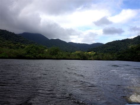 the water is very dark and choppy with mountains in the background