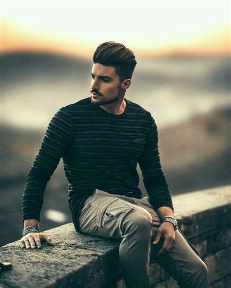 a man sitting on top of a stone wall